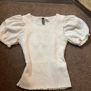 white crop top in white has ruffles at the end of the shirt